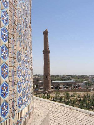 نمایی از ساقه‌ی گنبد و تنها گلدسته‌ی برپای مجموعه در باغ‌مزار گوهرشاد در هرات. همه چیز نشانگر آن است که تمام مناره‌ها نیز پوششی از کاشی و آینه داشته است و چه زیبا بوده است.