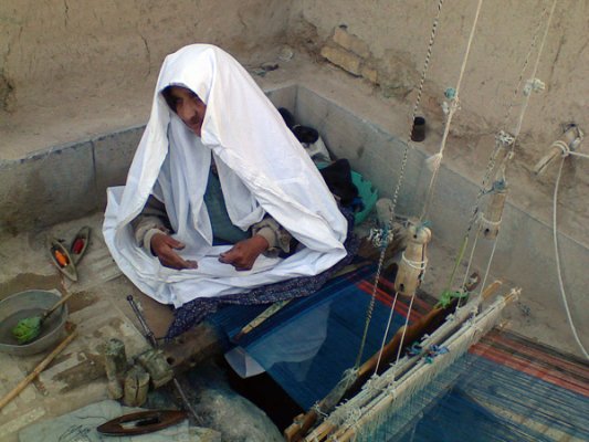 زنی سفید پوش در حال بافتن