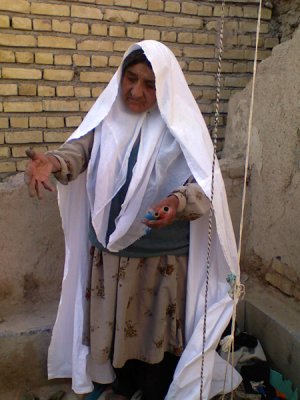 حتا زمان بافتن این زن چادر سفید خود را بر سر دارد.